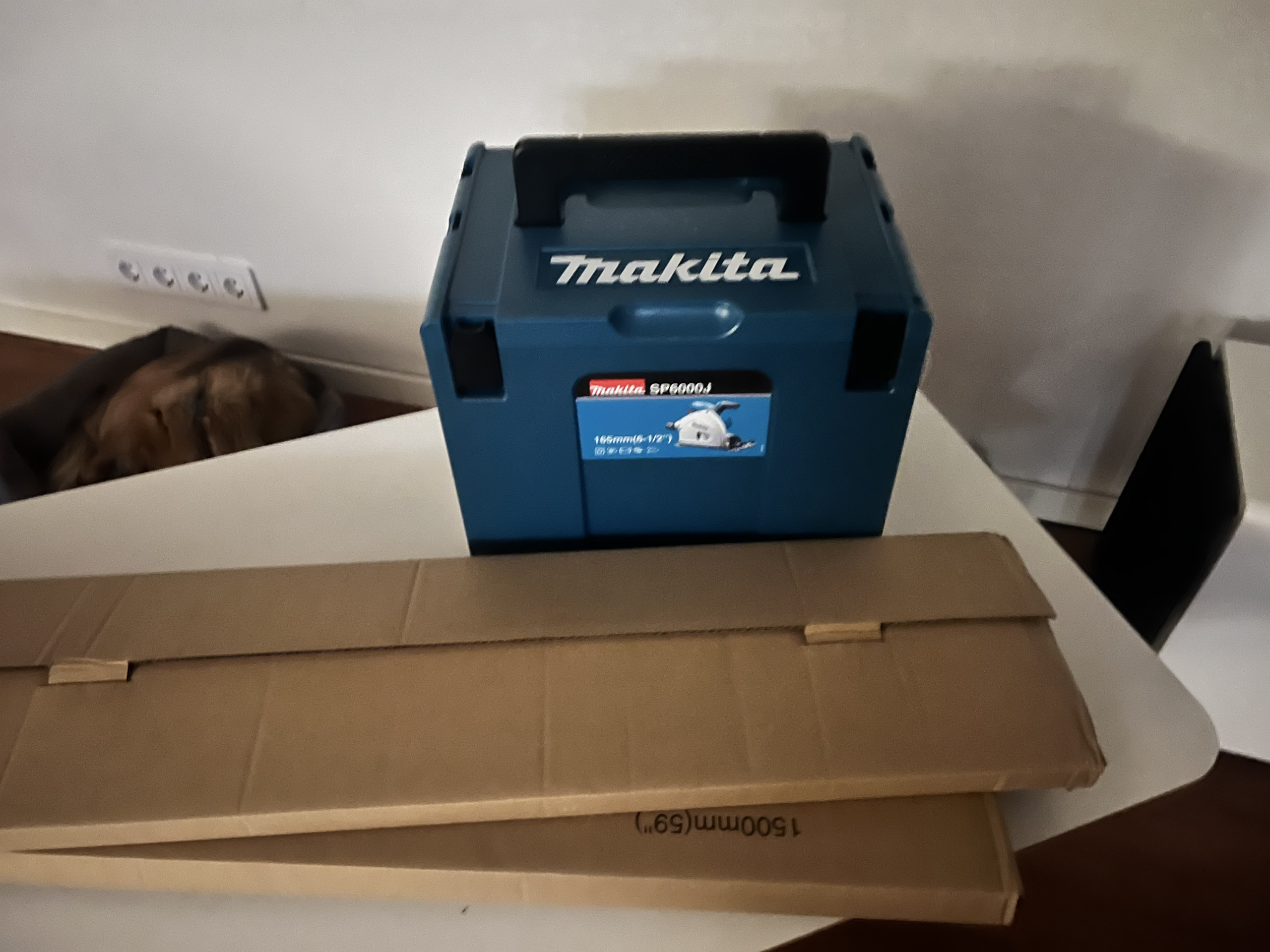 Verktygslåda från Makita och kartong i verkstaden.